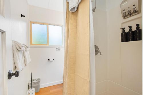 a white bathroom with a shower and a window at Mount Walker Suite, Room 12 at Mount Walker Inn in Quilcene