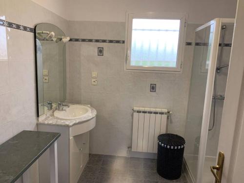 La salle de bains blanche est pourvue d'un lavabo et d'une douche. dans l'établissement Villa de 2 chambres avec piscine privee terrasse et wifi a Saint Gaudens, à Saint-Gaudens