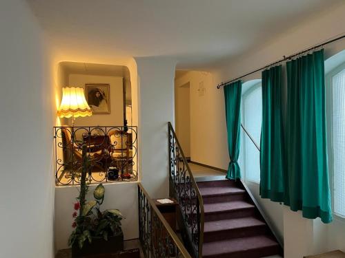 a stairway with a green curtain and a green window at City Hotel Post 22 in Braunau am Inn
