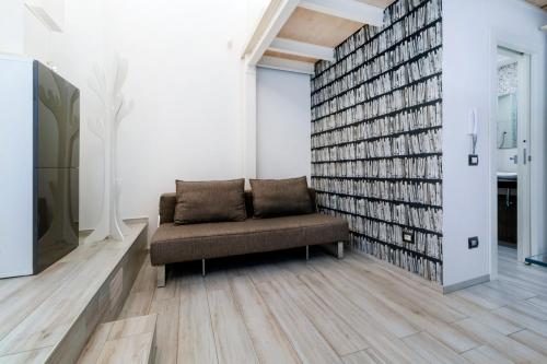 a room with a couch and a large wall of books at Stesicoro Exclusive House in Catania