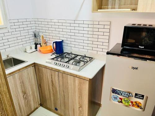 a kitchen with a stove top oven next to a refrigerator at Diaggello Homex Apartment in Lekki
