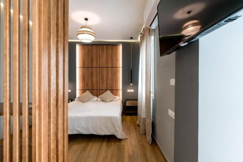 a bedroom with a white bed and a wooden wall at Studio with wifi at Sevilla in Seville