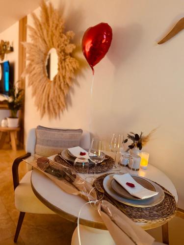 a table with a balloon and a table with plates and glasses at LoveRoom, La suite de l’extase in Puget-sur Argens