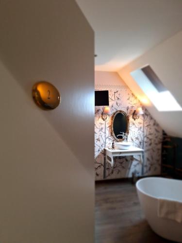 ein Bad mit einem Waschbecken und einem Spiegel in der Unterkunft Chambres d'hôtes - Au Clos d'Amande in Lasne