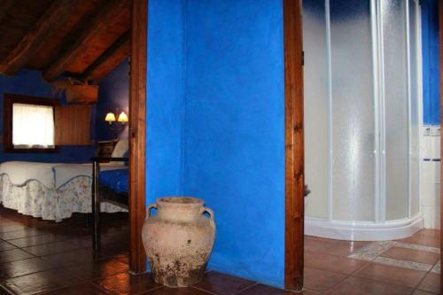5 bedrooms house with wifi at Santa Cruz de Moncayo في Santa Cruz de Moncayo: غرفة زرقاء مع مزهرية بجوار الجدار الأزرق