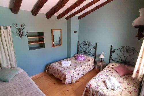 1 dormitorio con 2 camas y espejo en 3 bedrooms house with shared pool and terrace at Ores, en Orés