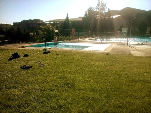 una persona parada en el césped cerca de una piscina en 3 bedrooms house with shared pool and terrace at Ores, en Orés