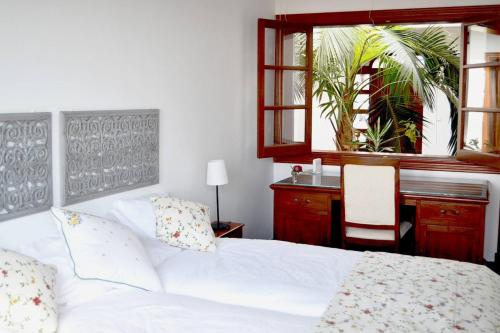 Schlafzimmer mit einem Bett, einem Schreibtisch und einem Fenster in der Unterkunft 4 bedrooms chalet with shared pool and wifi at Yaiza in Yaiza