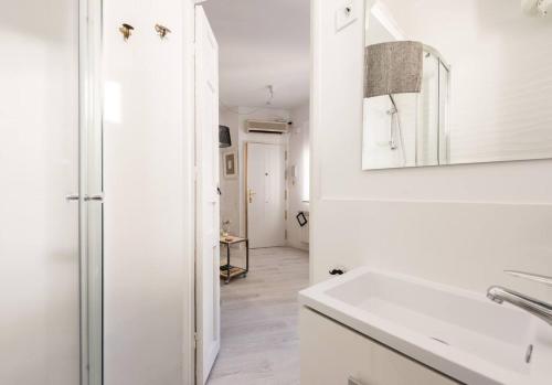 a white kitchen with a sink and a mirror at One bedroom property with wifi at Madrid in Madrid