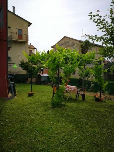 a yard with two trees and a table and chairs at One bedroom appartement with jacuzzi and wifi at Sant'Ippolito in SantʼIppolito