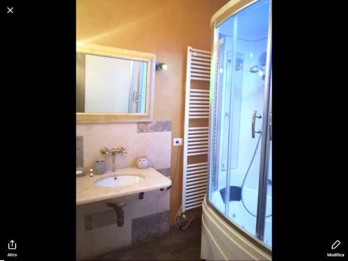 a bathroom with a sink and a glass shower at One bedroom appartement with jacuzzi and wifi at Sant'Ippolito in SantʼIppolito