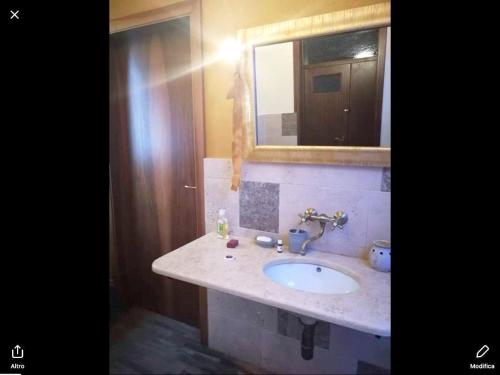 a bathroom with a sink and a mirror at One bedroom appartement with jacuzzi and wifi at Sant'Ippolito in SantʼIppolito