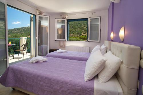 a purple bedroom with two beds and a balcony at Regina Ioanna Villas in Ayia Evfimia