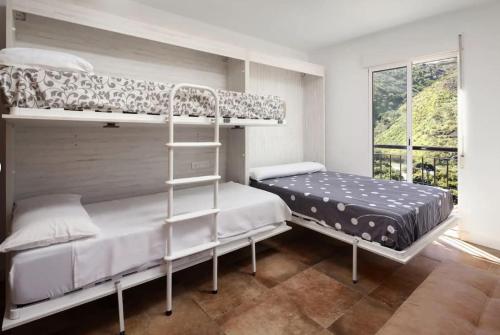 a bedroom with two bunk beds and a window at Villa Carrillos, 365-rentals in Benamargosa