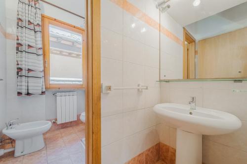 Baño blanco con lavabo y espejo en Appartamenti Norsi, en Capoliveri