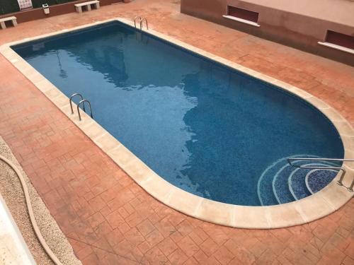 a large swimming pool with blue water at La Casa Algorfa Pool View Apartment by Delta in Coxhoe