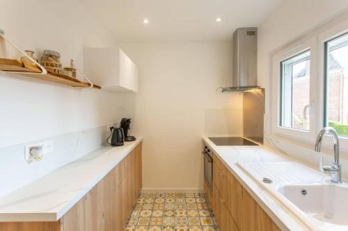 cocina con encimeras blancas, fregadero y ventana en Appartement d'une chambre avec wifi a Amiens en Amiens