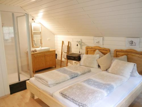 1 dormitorio con 2 camas y baño con lavamanos en Antonia´s Kaffeehäferl, en Eibiswald