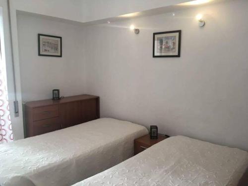 1 dormitorio con 2 camas y vestidor en One bedroom appartement with shared pool terrace and wifi at Albufeira 4 km away from the beach en Albufeira