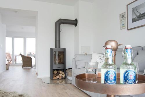 a living room with two bottles on a table with a fireplace at Oceanhouse in Olpenitz