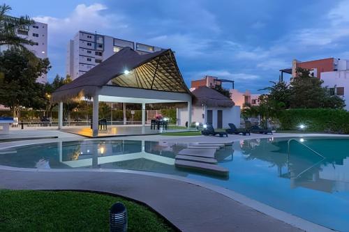 a swimming pool with a gazebo at night at Exclusive building 6 people 3 cable televisions 3 swimming pools balcony, in Cancún