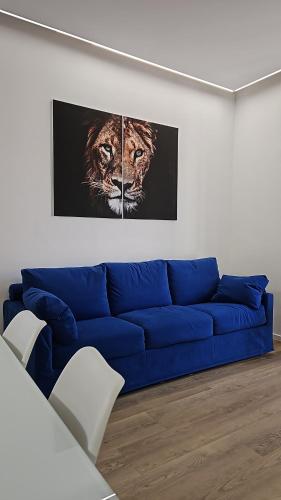 a blue couch in a living room with a picture of a tiger at The Rooms - Rho-Fiera Milano in Pero