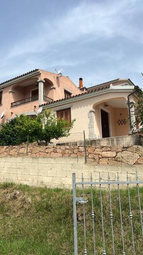 ein Haus mit einem Zaun davor in der Unterkunft Casa vacanze a Budoni in Budoni