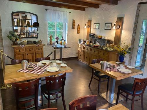 eine Küche mit Holztischen und -stühlen sowie eine Küche mit einer Theke in der Unterkunft Ferienhof Bludnik in Kaupen
