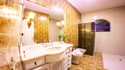 W łazience znajduje się umywalka, prysznic i toaleta. w obiekcie Dom Ravello w mieście Telêmaco Borba