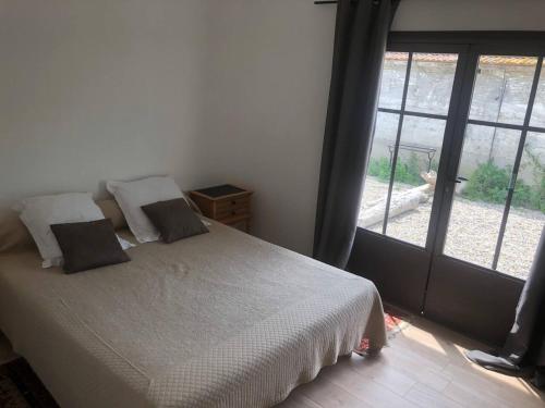 a bedroom with a bed and a large window at Propriete d'une chambre avec piscine partagee et wifi a Saint Gilles in Saint-Gilles