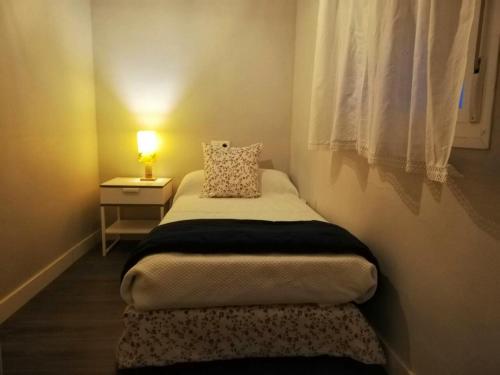 ein kleines Schlafzimmer mit einem Bett und einem Fenster in der Unterkunft 2 bedrooms apartement with wifi at Sevilla in Sevilla
