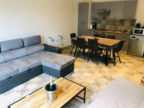 sala de estar con sofá azul y mesa en Chalet d'une chambre avec piscine partagee terrasse et wifi a Clermont Creans, en La Flèche