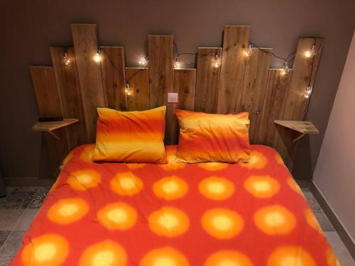 une chambre avec un grand lit avec une tête de lit en bois dans l'établissement Chalet charmant à Clermont-Créans avec piscine partagée, à La Flèche