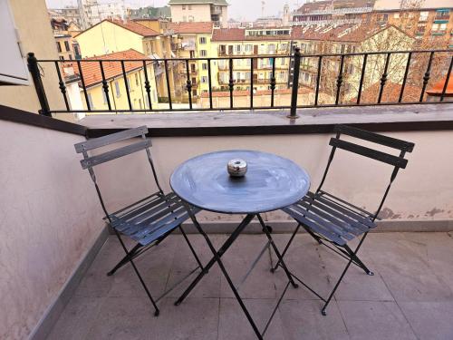 d'une table bleue et de deux chaises sur un balcon. dans l'établissement heart of milan Apartment, à Milan