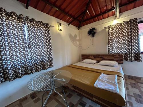 Un dormitorio con una cama y una mesa de cristal. en Hiranya Farm Stay, en Sawantwadi