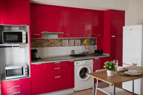 a kitchen with red cabinets and a washing machine at Apartamento El Catavino in Jerez de la Frontera