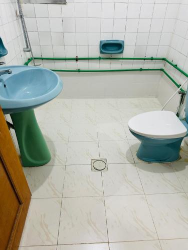 a bathroom with a blue sink and a toilet at Room for rent in Sharjah