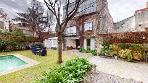 een huis met een zwembad in een tuin bij BENS L'Hôtel Palermo in Buenos Aires