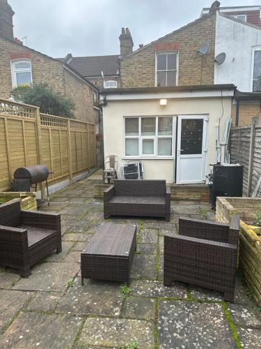 un patio con sillas y mesas frente a una casa en Best east London location en Londres