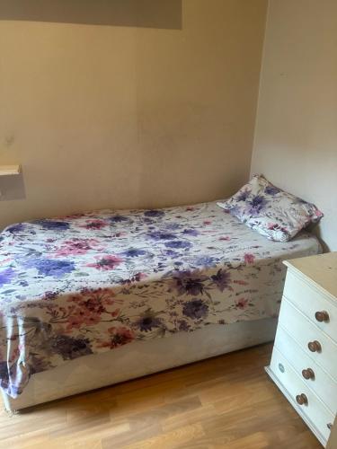 a bed with a floral comforter in a bedroom at Best east London location in London