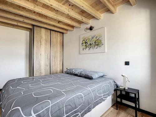een slaapkamer met een bed en een houten plafond bij Appartement d'exception, terrasse vue Pic du Midi in Bagnères-de-Bigorre