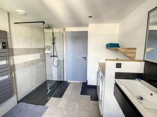 een badkamer met een douche, een wastafel en een wastafel bij Appartement d'exception, terrasse vue Pic du Midi in Bagnères-de-Bigorre