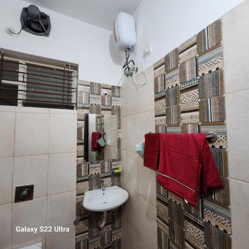 baño con lavabo y toalla roja en Om Villa, en Bhopal