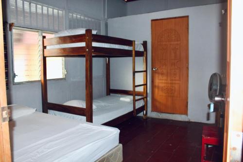 a room with two bunk beds and a door at Surf Town Hostel in San Juan del Sur