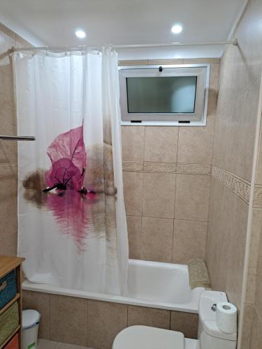 une personne dans une baignoire portant un parapluie rose dans l'établissement Super Penthouse Ocean View, à San Miguel de Abona