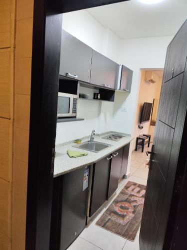 a kitchen with a sink and a microwave at Gentle Breeze Studio 2 in Amman