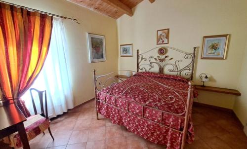 a bedroom with a red bed and a window at Agriturismo Colle delle Stelle in Mergo