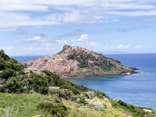 a town on top of a hill next to the ocean at L'Attico Blu - Affitti Brevi Italia in Valledoria