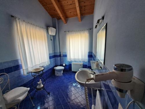 baño de azulejos azules con lavabo y aseo en Agriturismo Colle delle Stelle, en Mergo