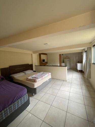 Cette grande chambre comprend deux lits et une salle de bains. dans l'établissement Kitnet agradável Alto Caparaó MG, à Caparaó Velho